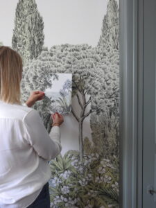 Julie Porcella, décoratrice d’intérieur à Grenoble et en Isère, travaillant sur un projet de papier peint panoramique